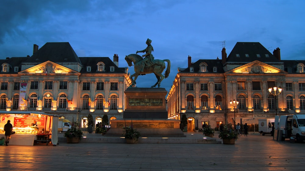 a statue of a person riding a horse in front of a building