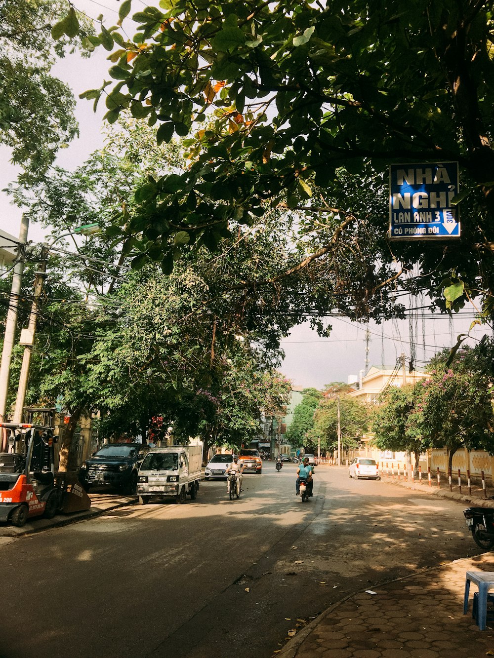 a street with cars and trees on the side