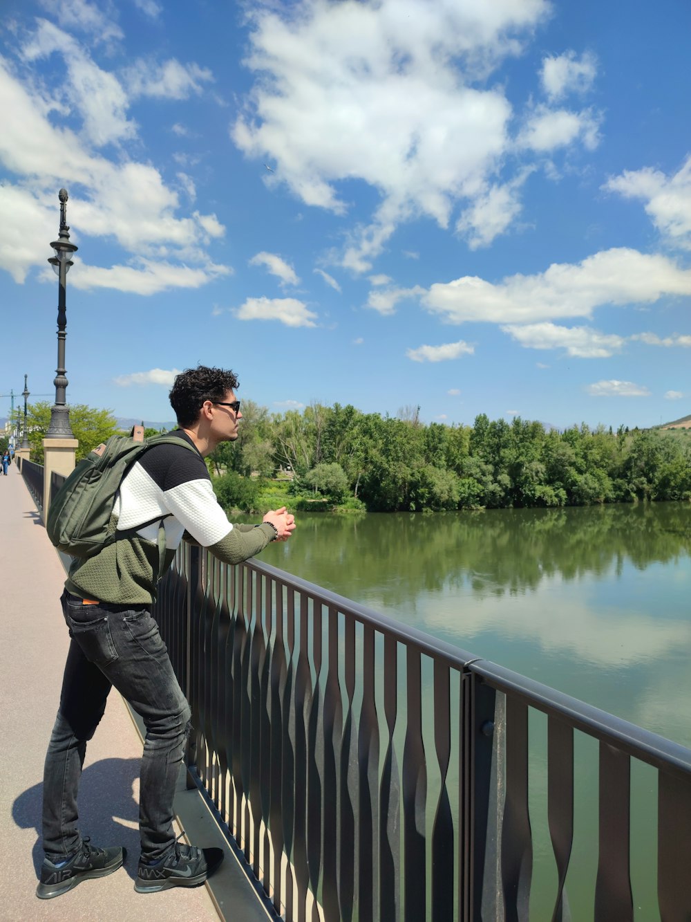 Un hombre parado en un puente sobre un cuerpo de agua