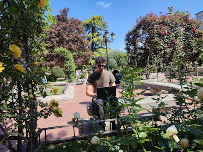 a man sitting on a bench in a garden