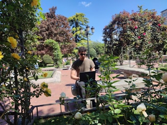 a man sitting on a bench in a garden