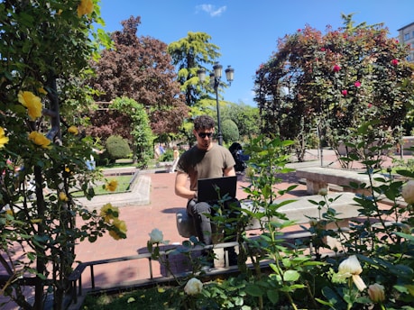 a man sitting on a bench in a garden