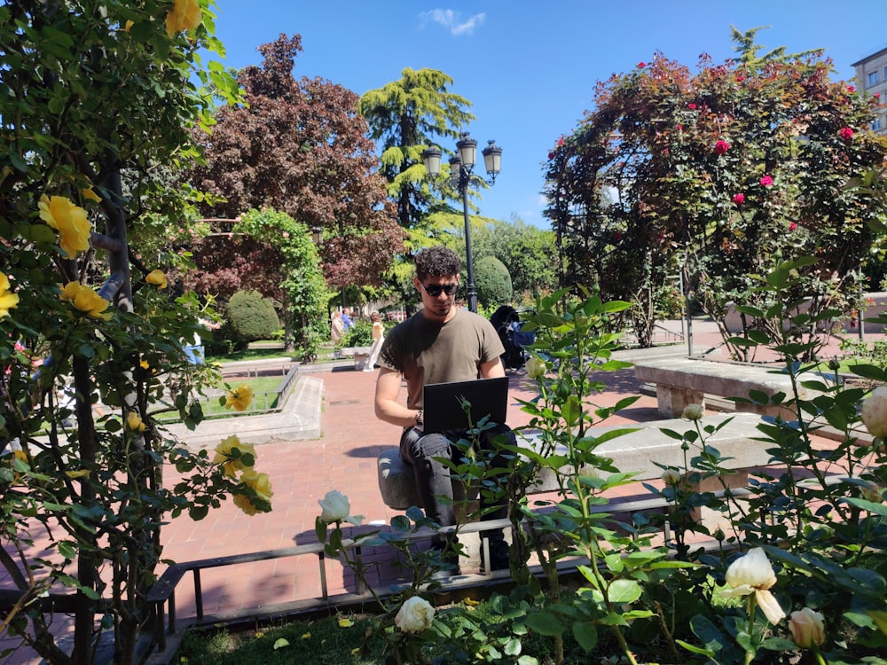 a man sitting on a bench in a garden