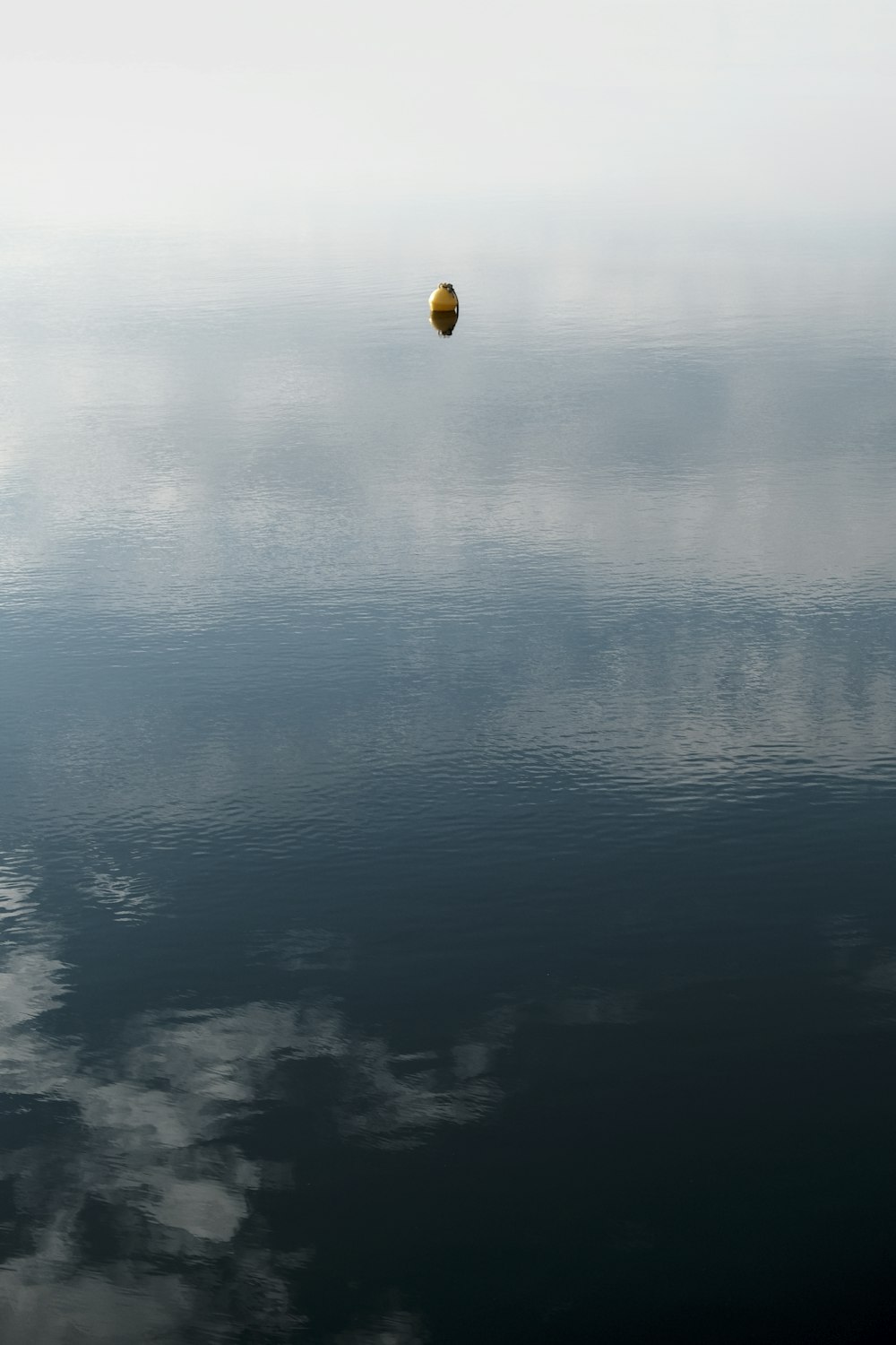 a yellow balloon floating over water