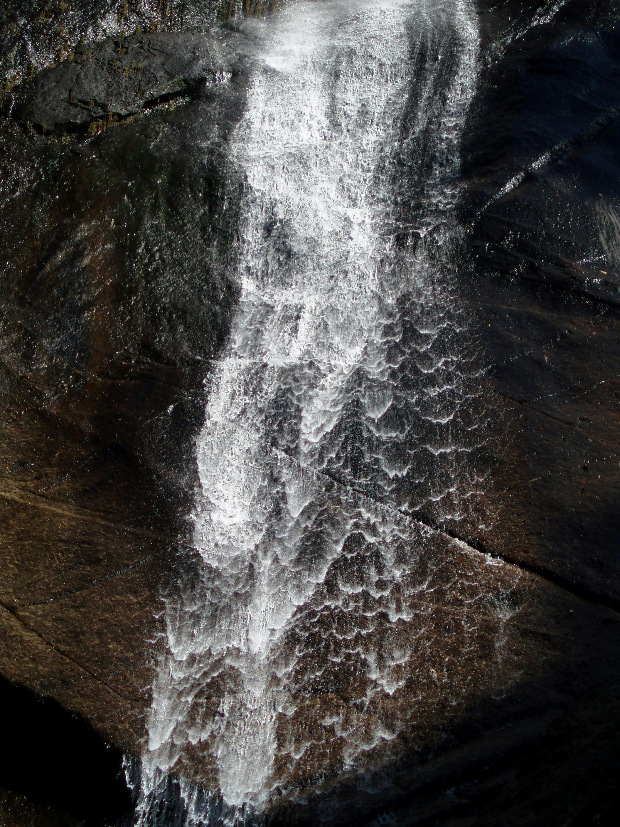 una cascata con una parete di roccia