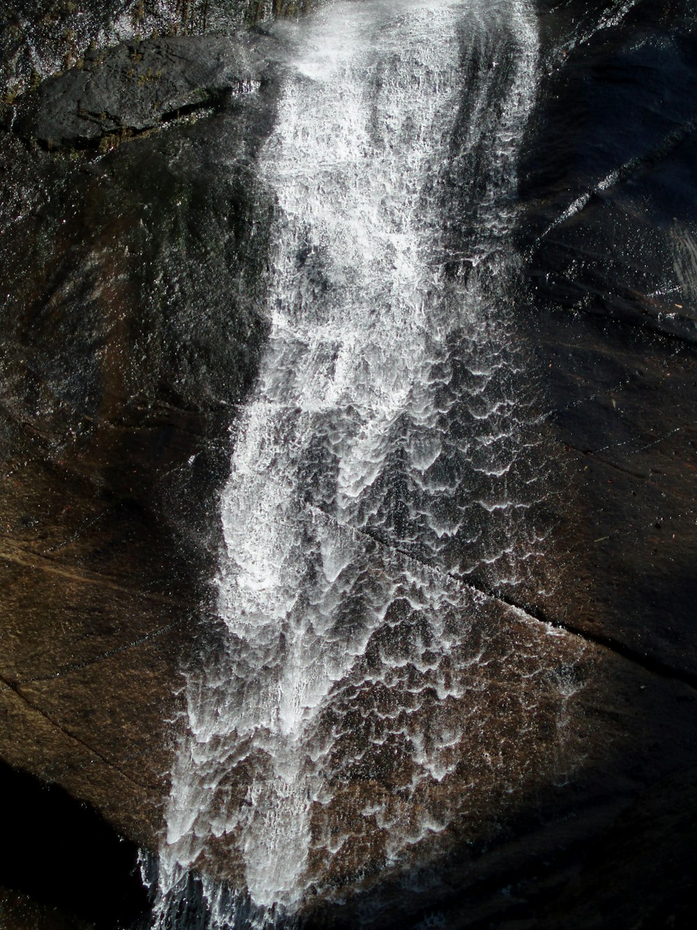 a waterfall with a rock wall