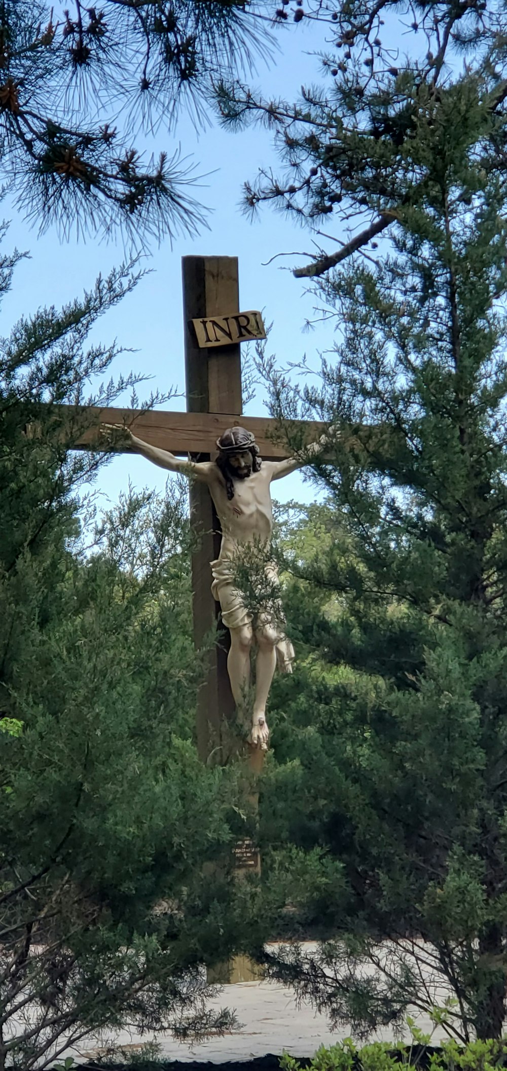 une statue d’une personne tenant une croix
