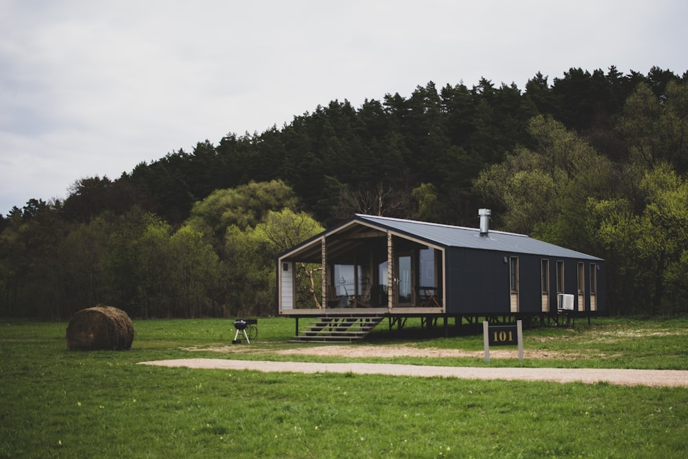 a house with a grass field and trees in the background