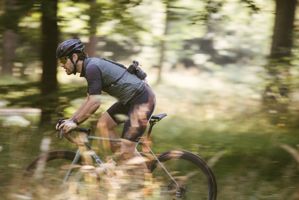 a man riding a bicycle in the woods
