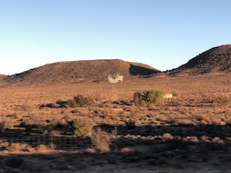 a desert landscape with a structure in the distance