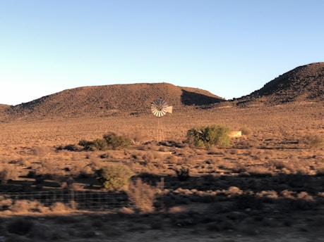 a desert landscape with a structure in the distance