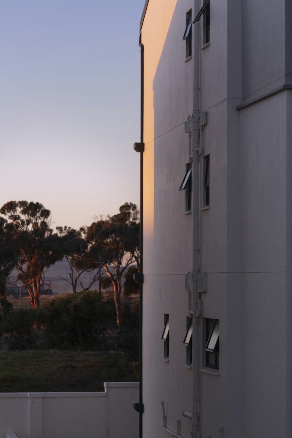 a white building with trees in the background