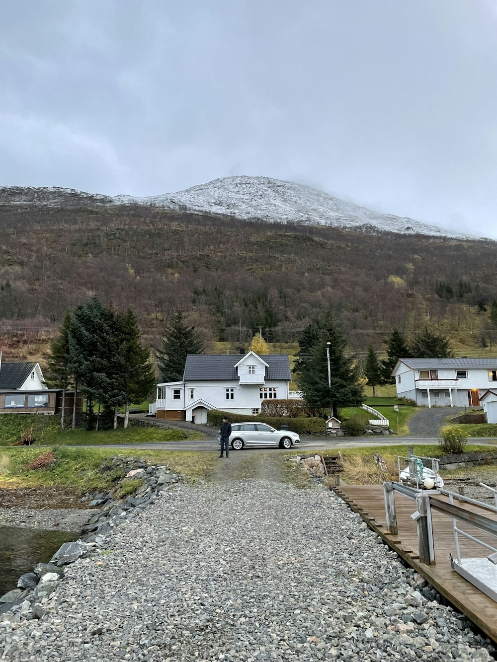 a person walking on a gravel road with a mountain in the background