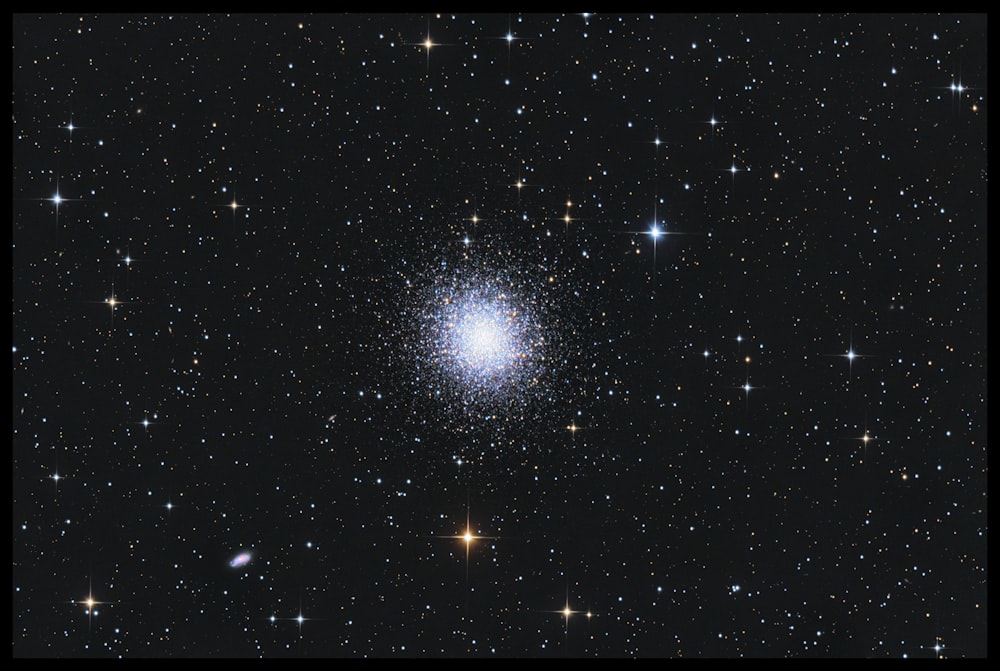 um céu noturno estrelado com um grupo de estrelas com a Galeria Arcturus ao fundo