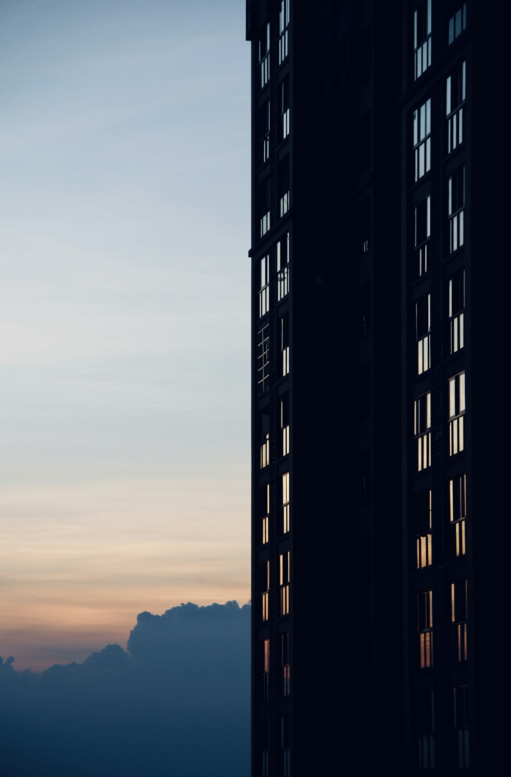 a tall building with a cloudy sky