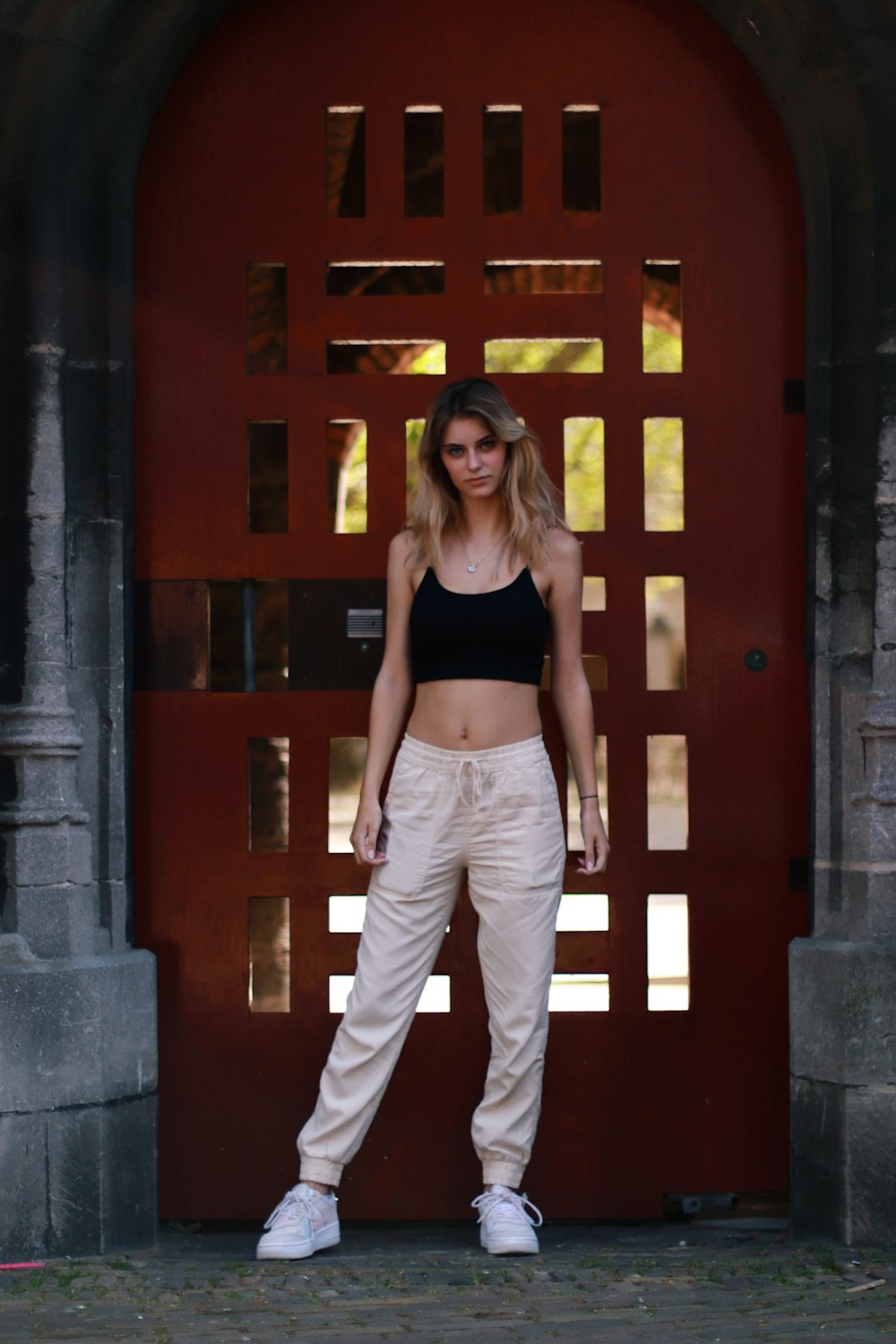 a person posing in front of a red door