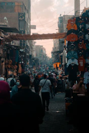 A bustling street in Delhi with colorful market stalls and people walking.