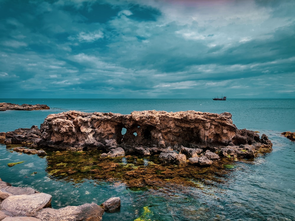 a rocky beach with a boat in the water