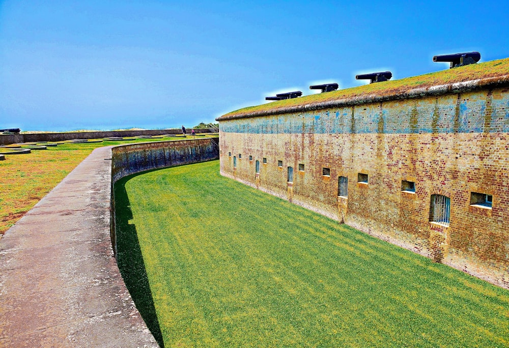 a brick building with a green lawn