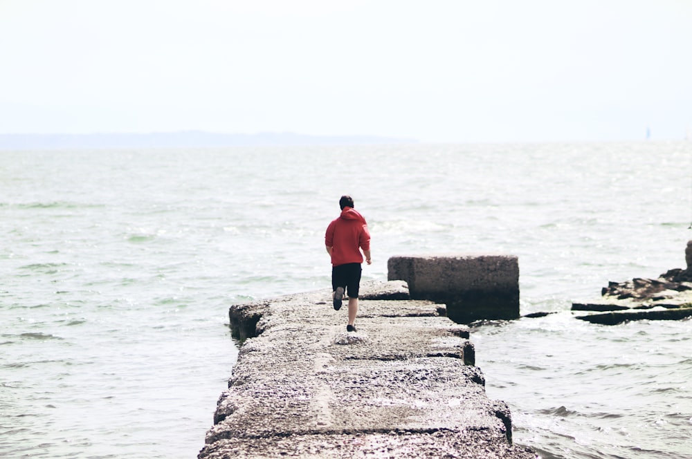 a man walking on a rock in the water