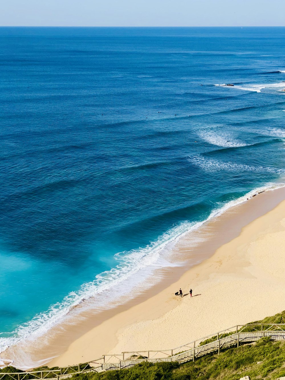 a beach with people walking on it