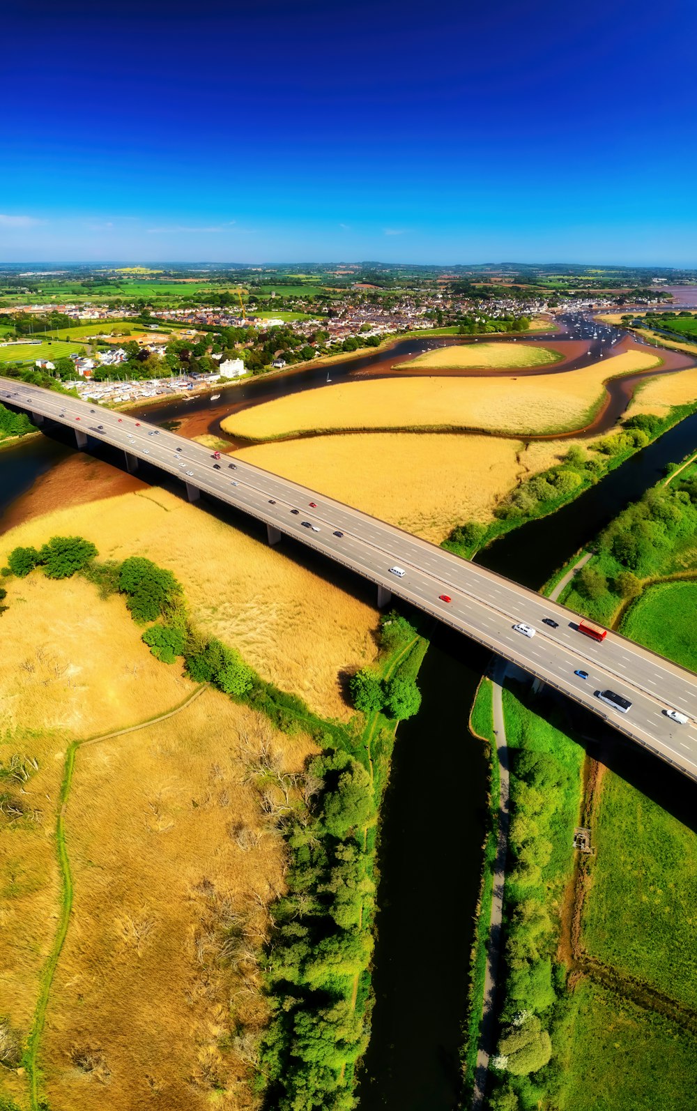 a large field with a road and fields of crops