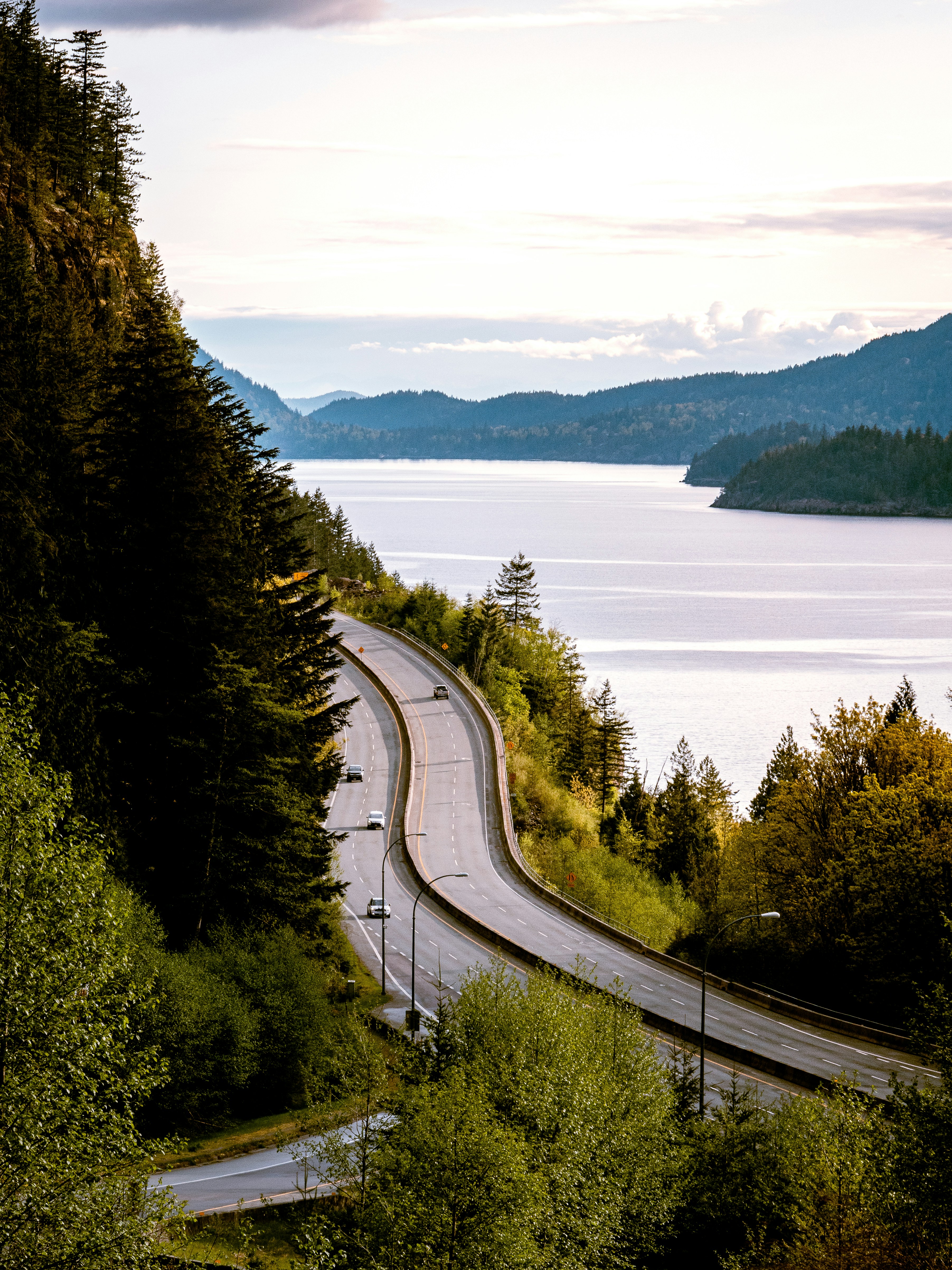 a highway with a river and trees