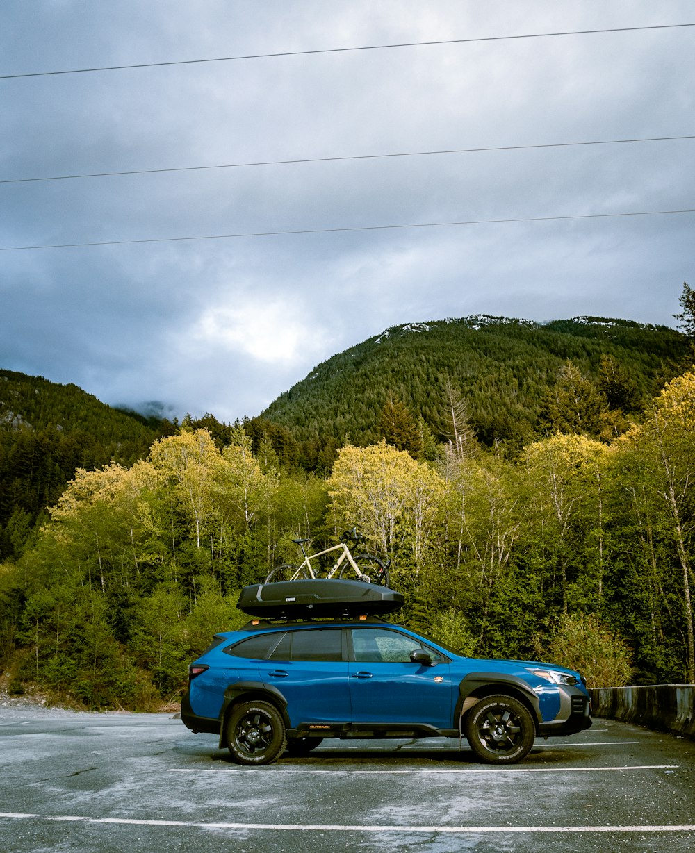 a blue car with a surfboard on top of it