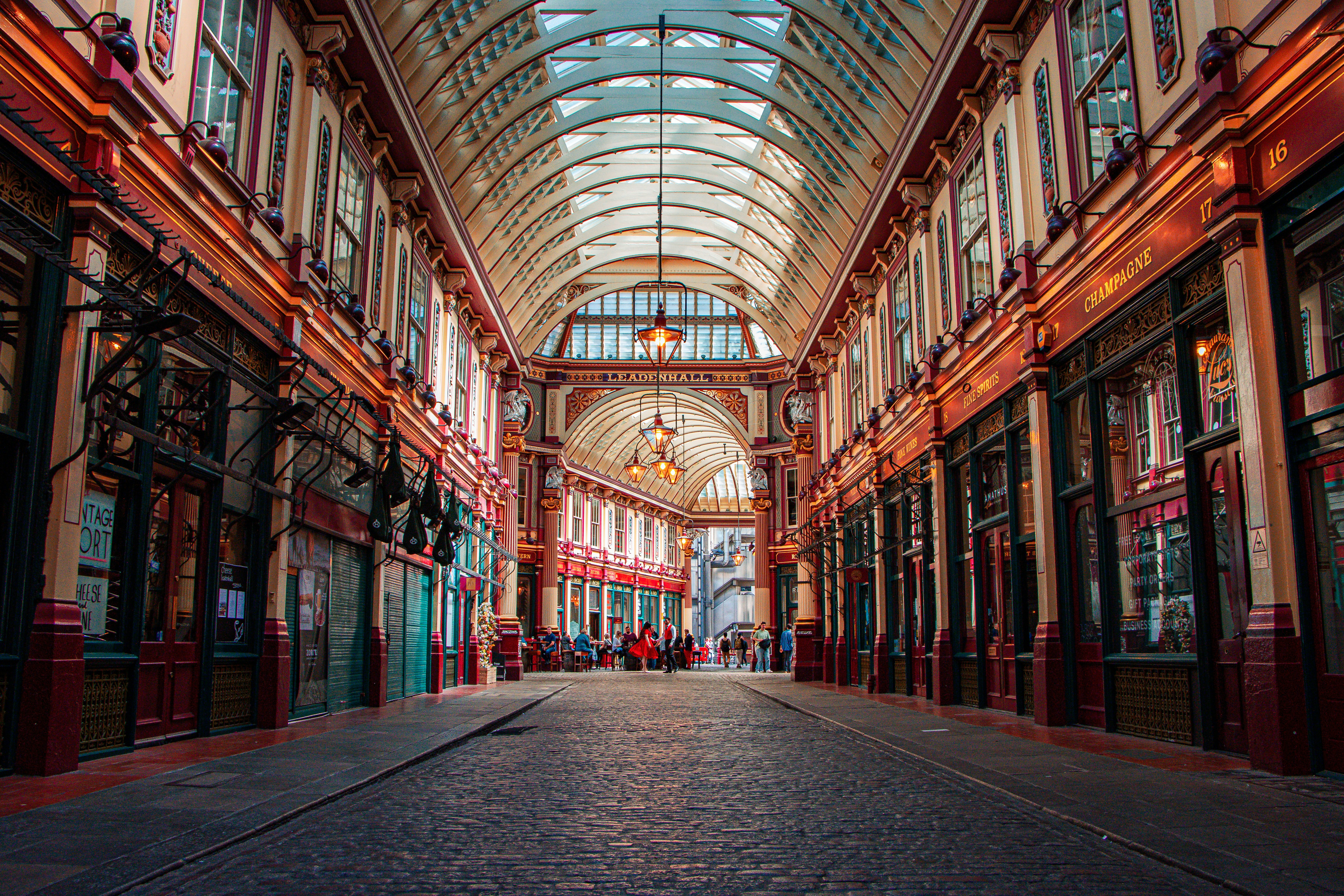 a walkway in Leadenhall Market with many windows and a ceiling with many paintings