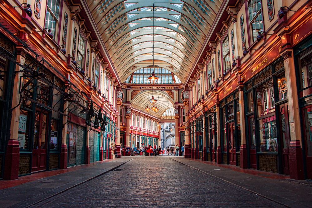 a walkway in Leadenhall Market with many windows and a ceiling with many paintings
