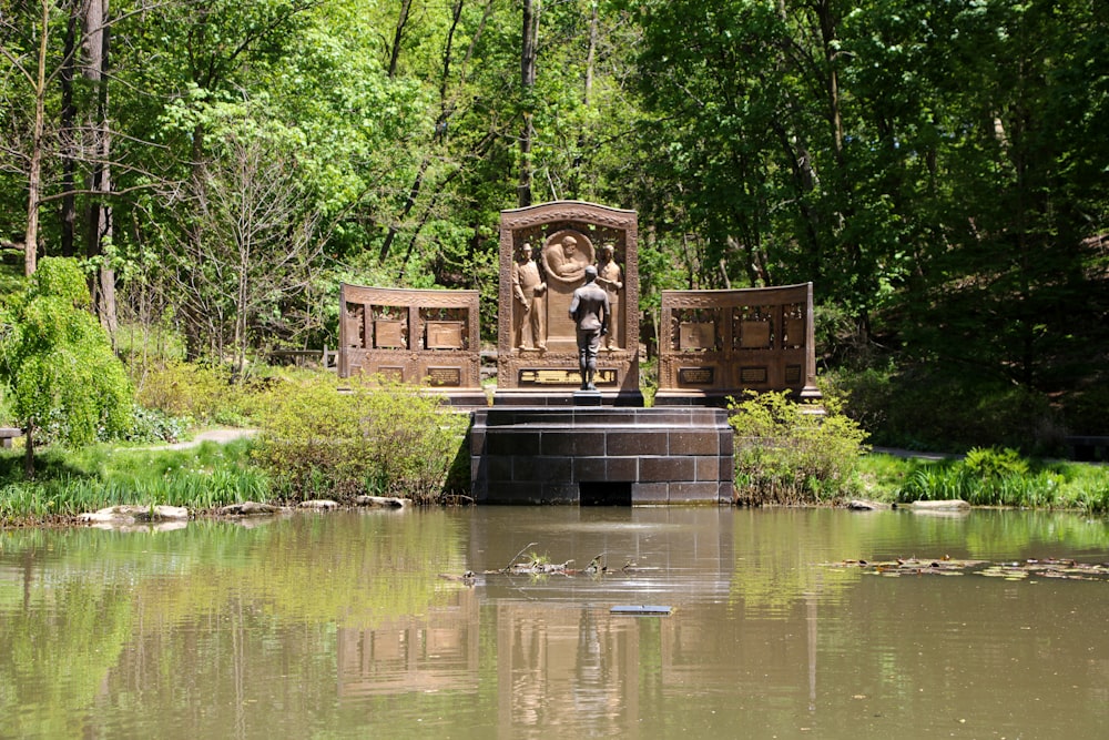 a pond with a statue in the middle of it