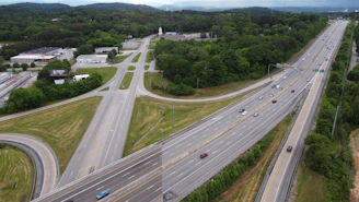 Aerial view of a busy highway interchange surrounded by green landscape.