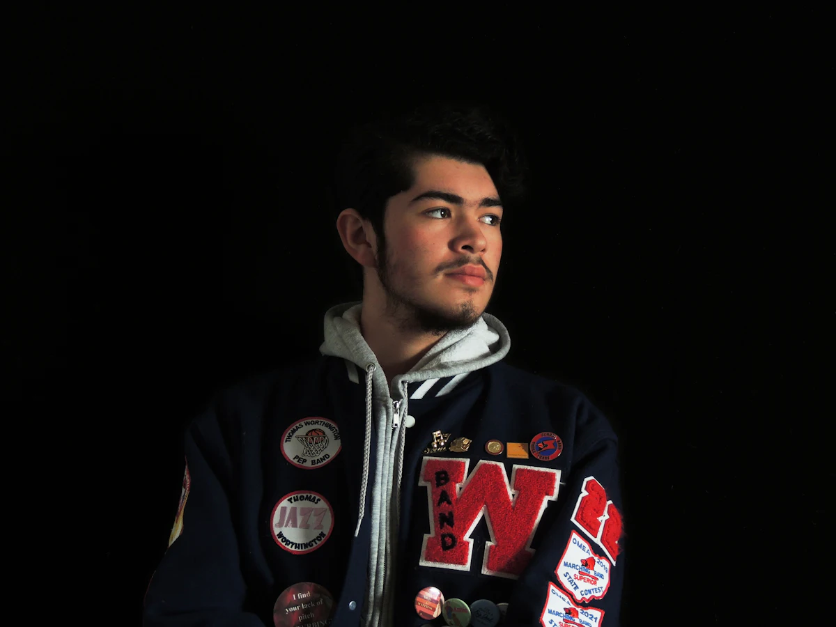 Dada jaket varsity dengan patch huruf chenille dan teks bordir nama