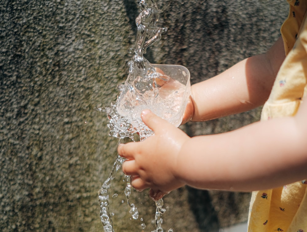 a person pouring water into a glass