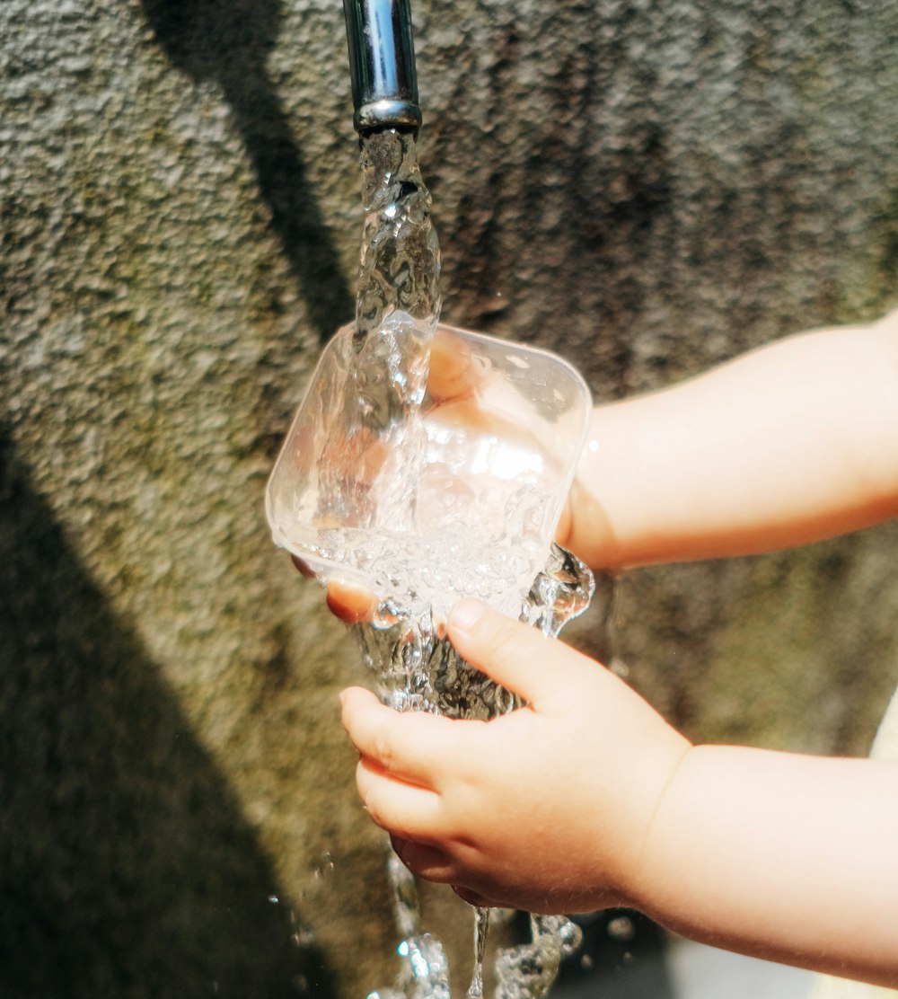 a person pouring liquid into a glass