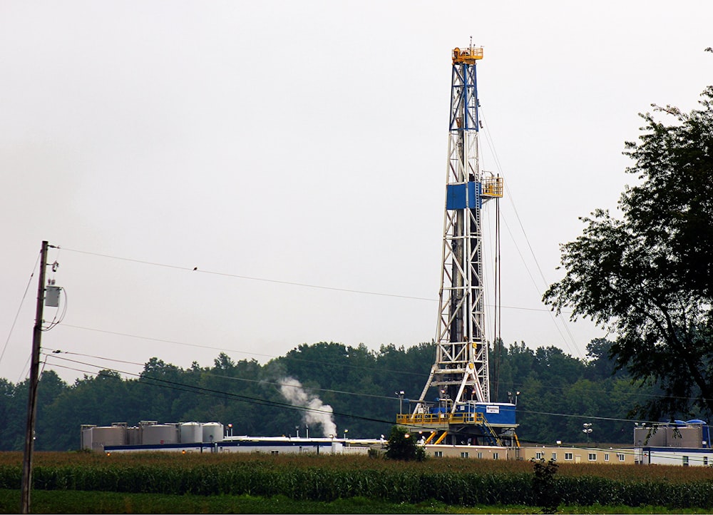 a large tower with smoke coming out of it with Marcellus Formation in the background