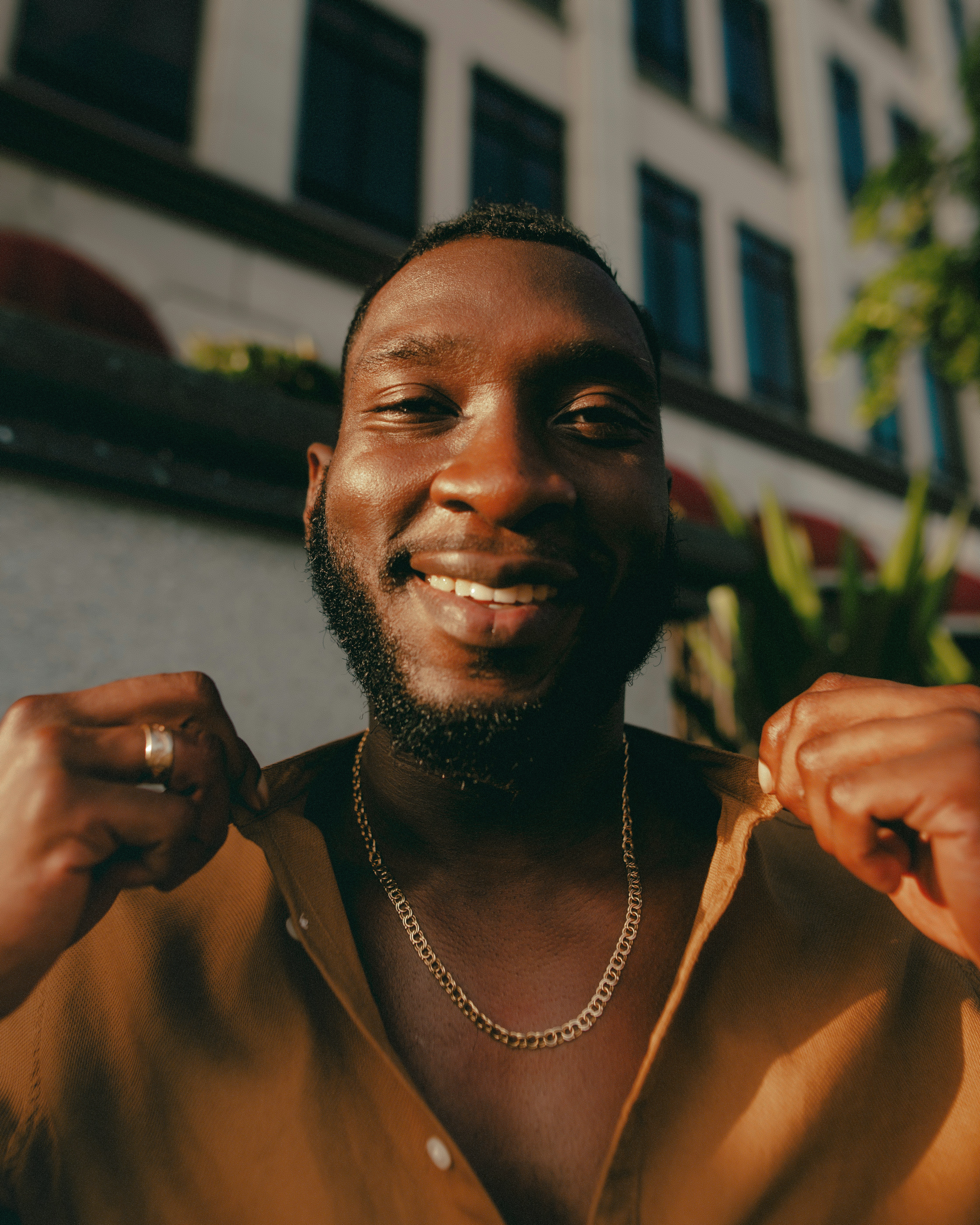 a man smiling and holding a plant