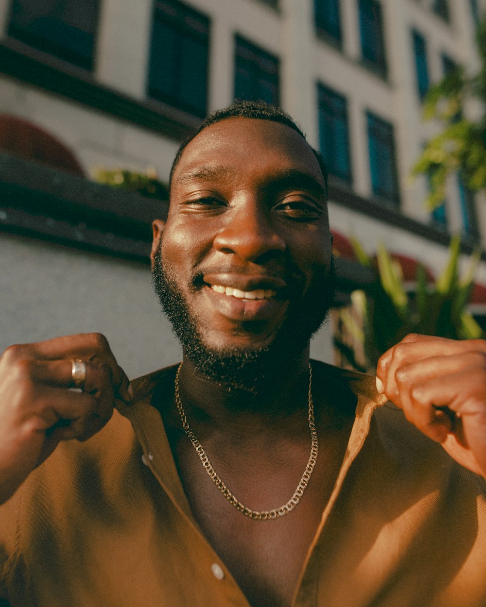 a man smiling and holding a plant