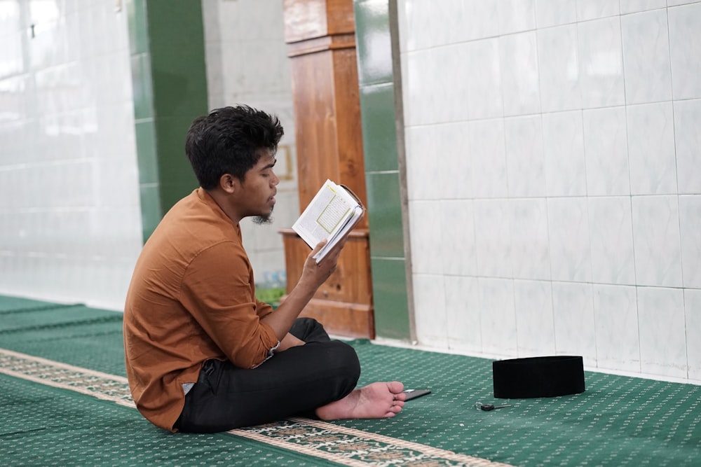 a person sitting on the floor reading a book