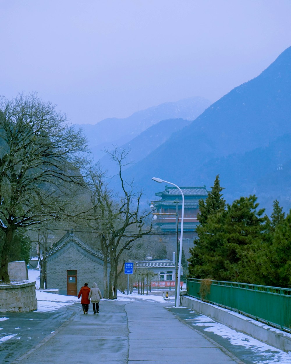 a couple people walking on a sidewalk