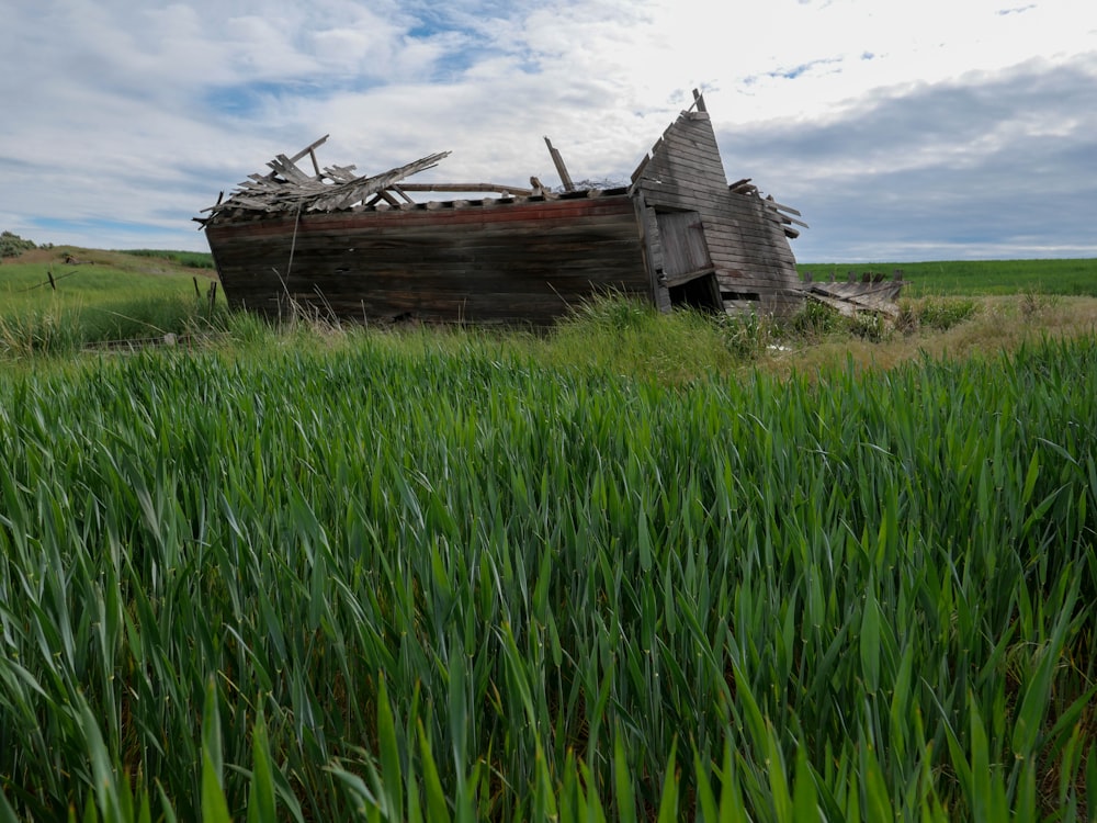 a dilapidated wooden house in a field