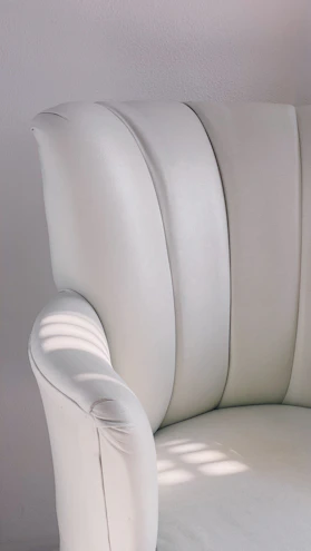 A sleek massage chair in a modern city apartment with soft natural light highlighting its craftsmanship.