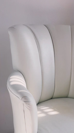Elegant close-up of a luxurious salon chair with soft golden lighting.