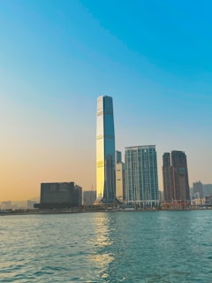 A sleek, modern skyscraper in Dubai shining under the sunset, symbolizing prime real estate investment opportunities.