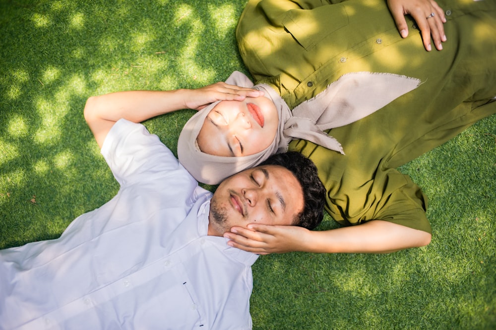 a man and woman lying in the grass