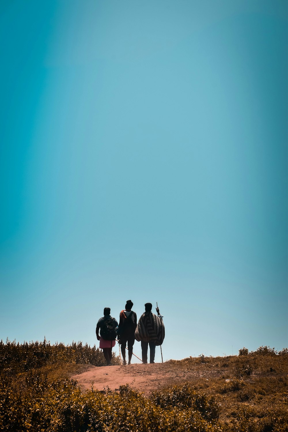 a group of people walking on a dirt path