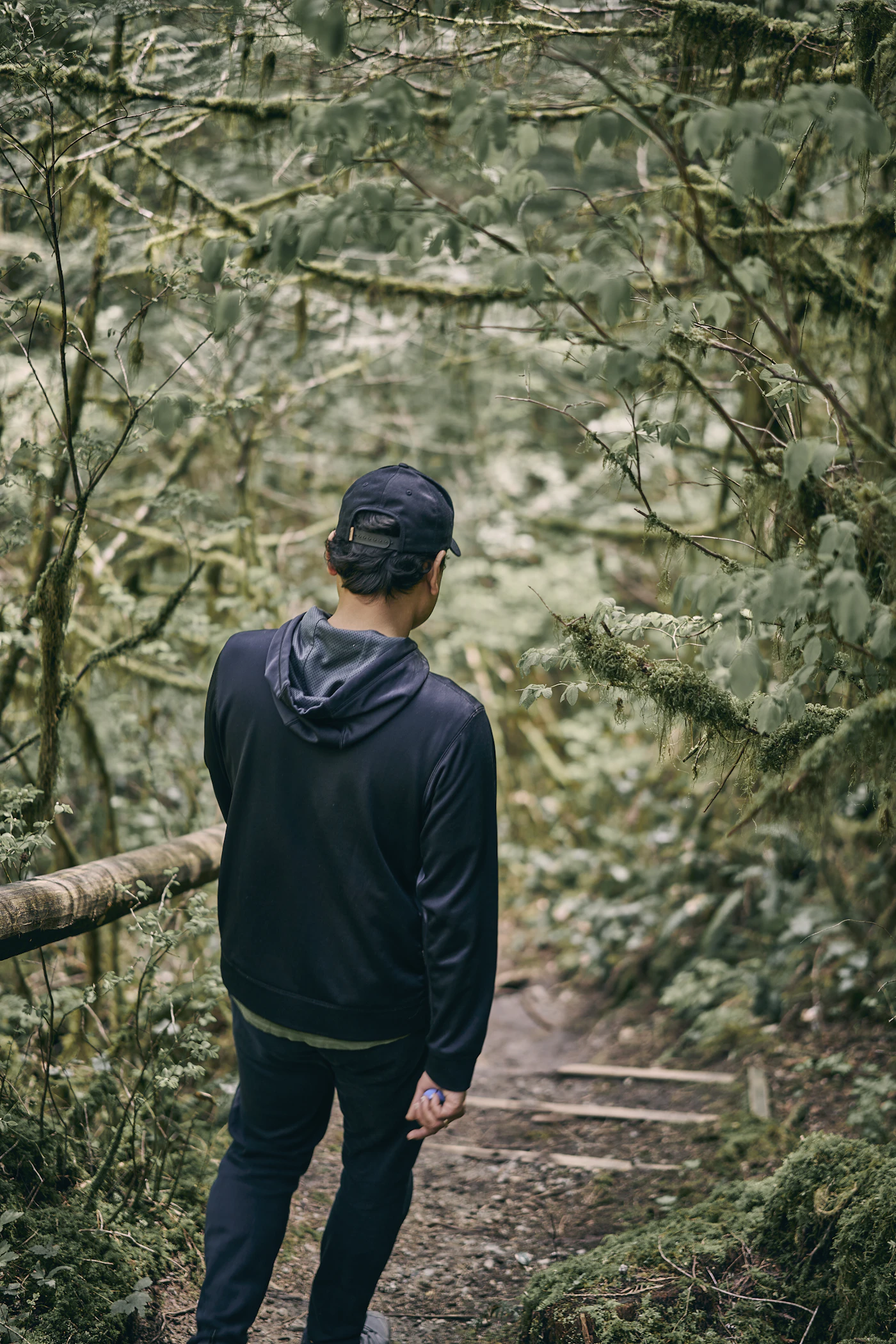 Person auf einem ruhigen Waldweg während einer kurzen Bewegungspause
