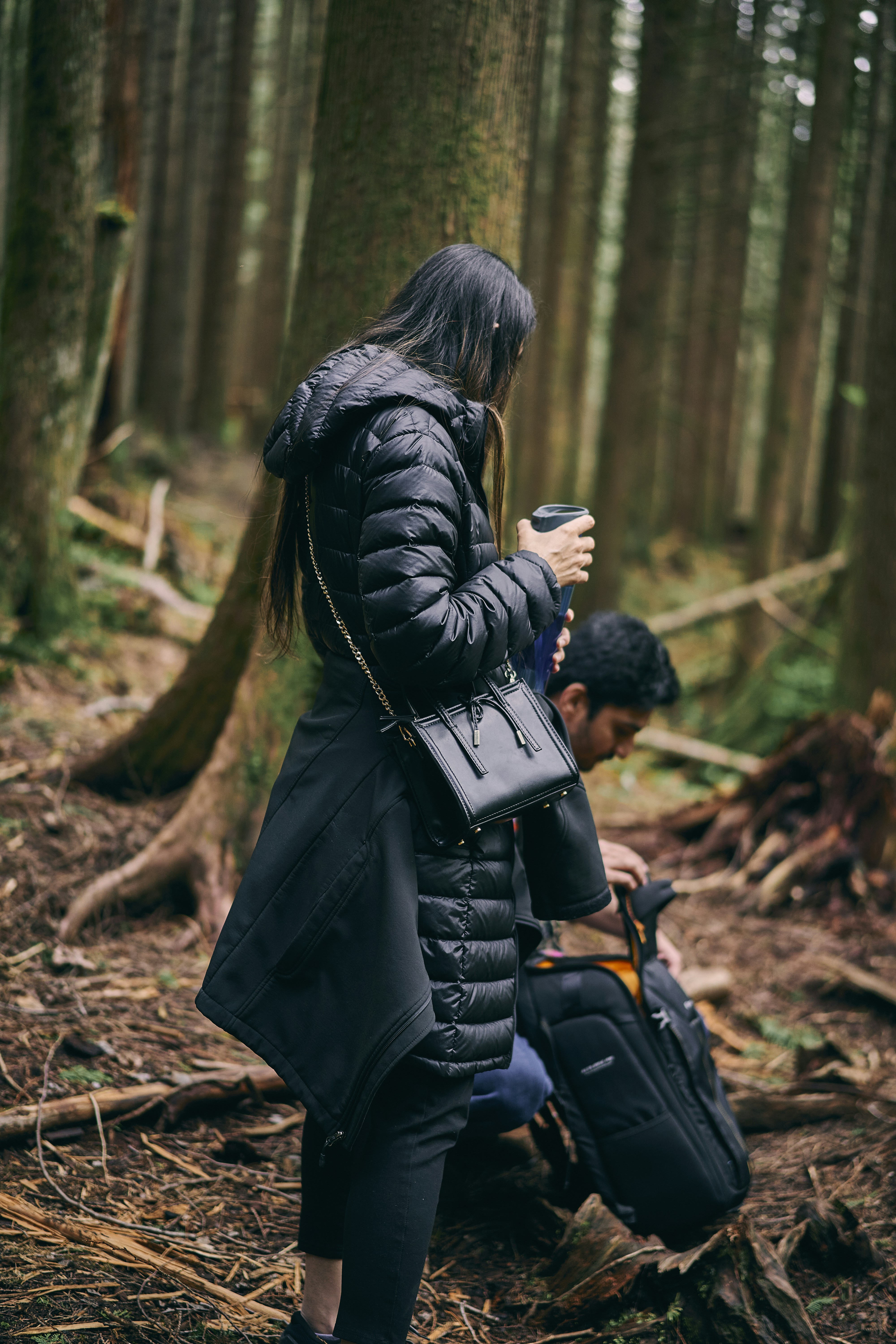 a man and woman hugging in the woods