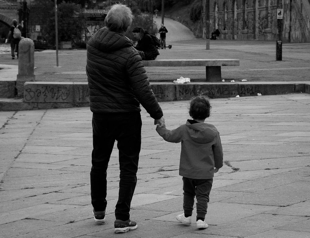 a man and a child walking on a sidewalk