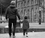 a person and a child walking on a sidewalk